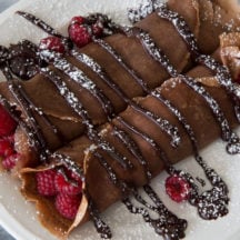 Chocolate Raspberry Crepes - These indulgent crepes are made with a chocolate batter and filled with fresh raspberries and doused with rich, chocolate ganache. YUM!