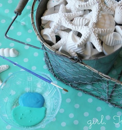 bucket of plaster of paris seashells, blue paint, on blue polka dot tablecloth