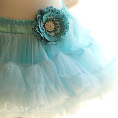 closeup of teal pettiskirt on mannequin with flower on waistband
