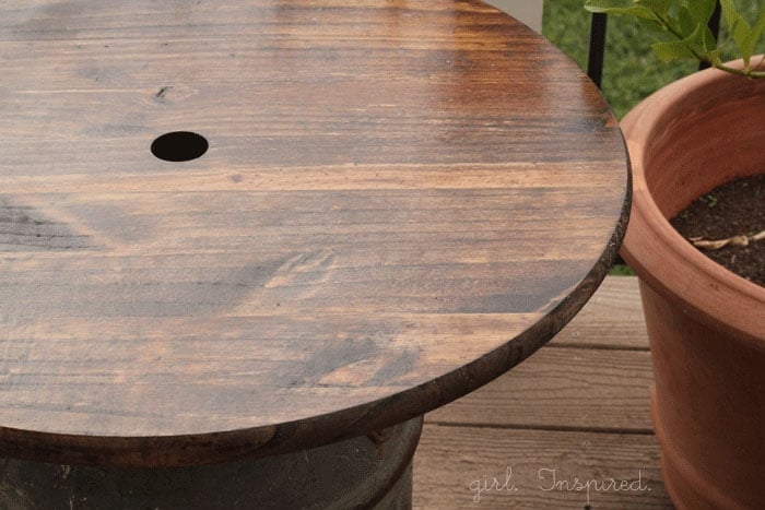 stained and sealed round wooden side table top with hole drilled in center