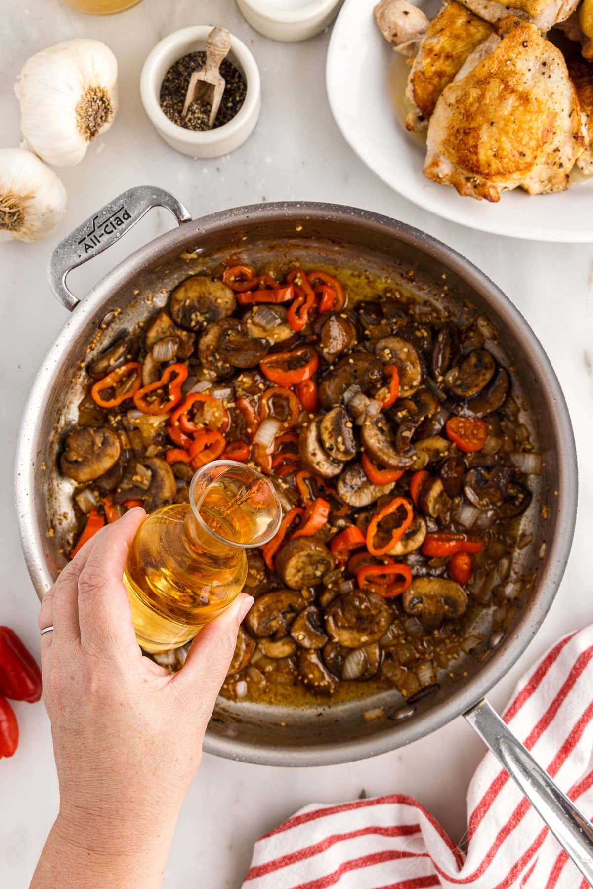 Pouring the cooking sherry into the skillet with the vegetables.