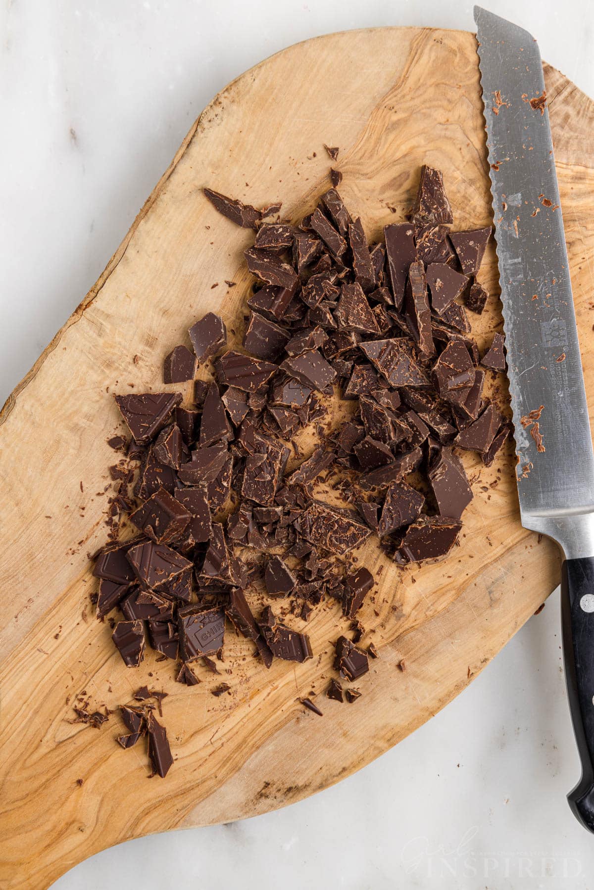 Chopped chocolate on cutting board with knife.