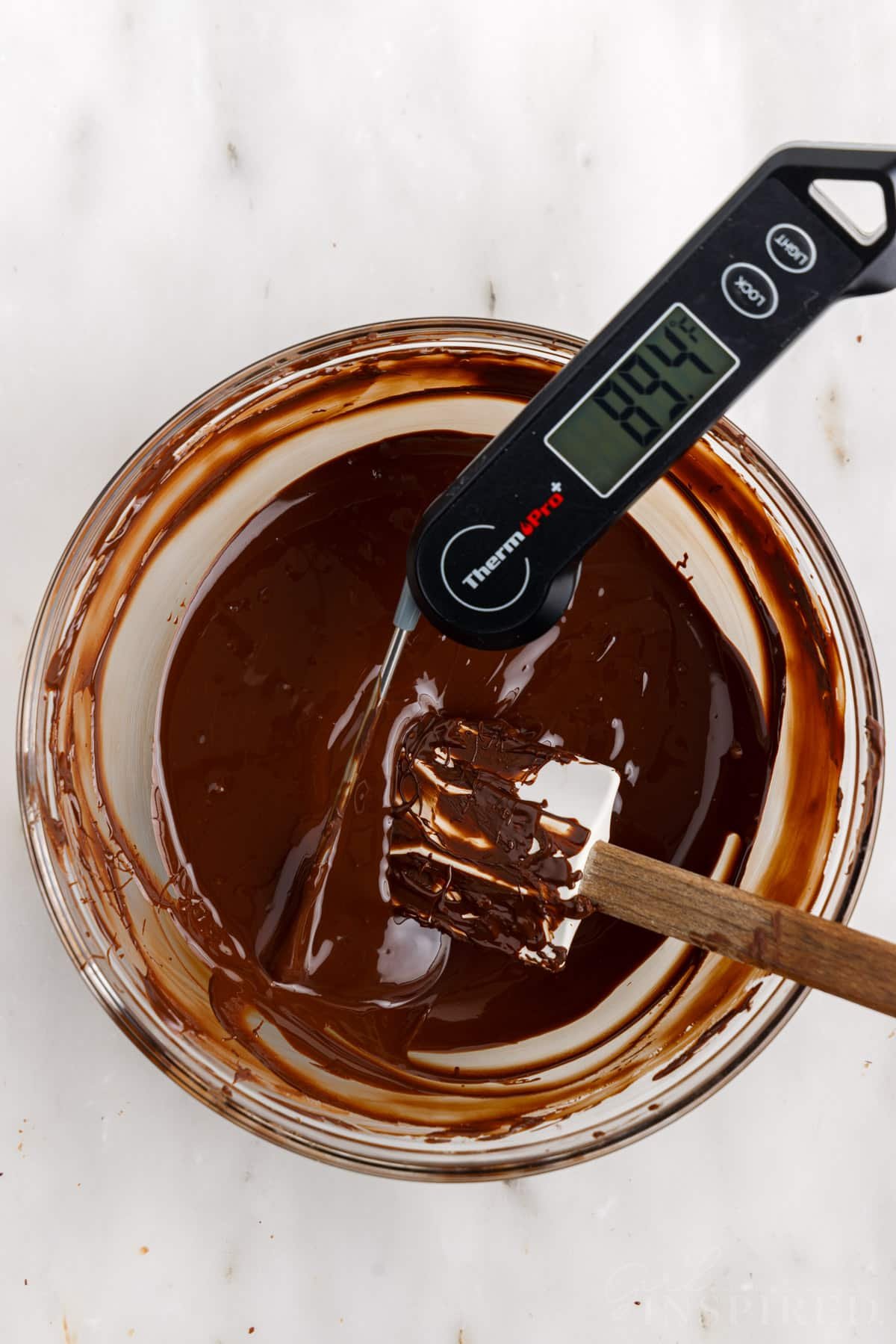 Melted chocolate with digital thermometer showing 89°F.