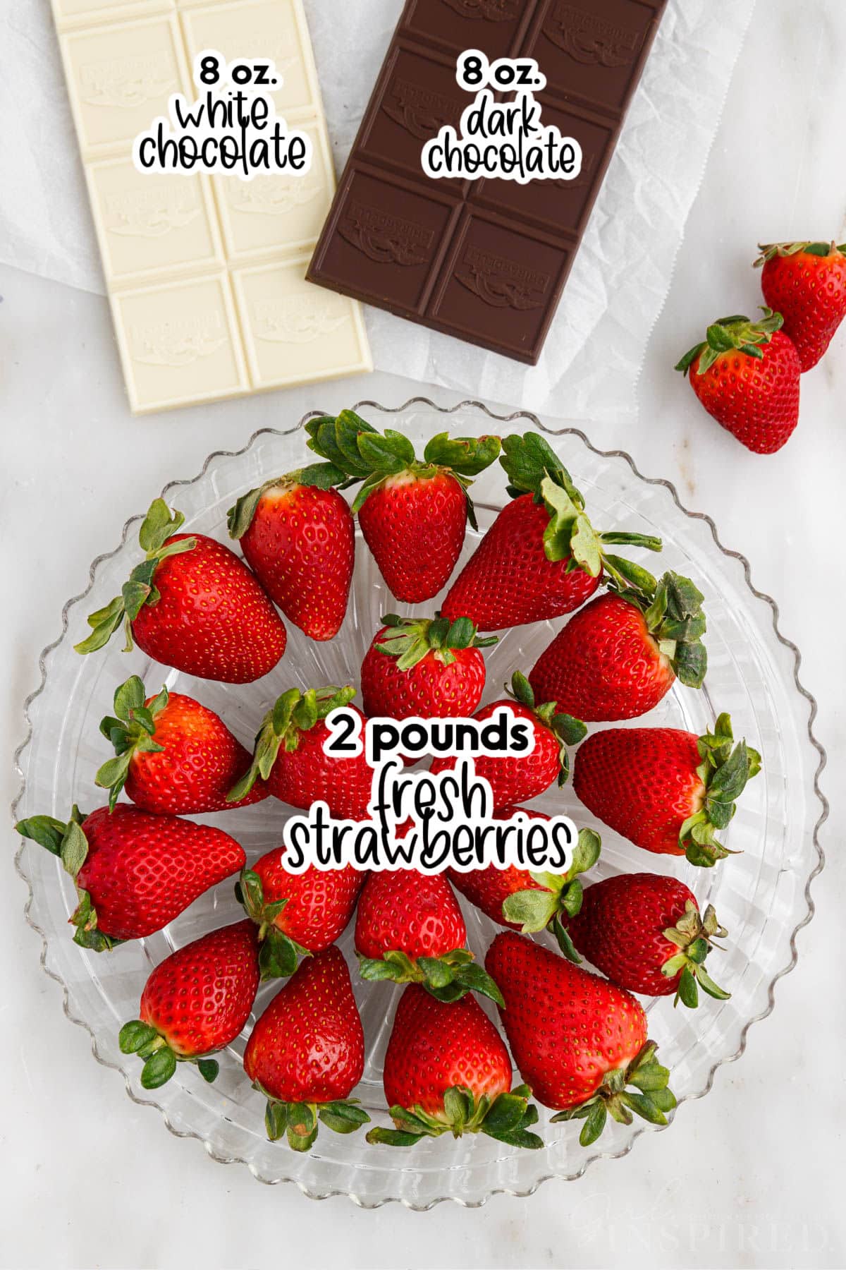 Tray of fresh strawberries, a bar of white chocolate, and a bar of dark chocolate with text labels.