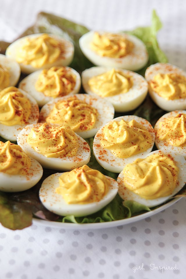 deviled eggs with swirled tops on a bed of lettuce 