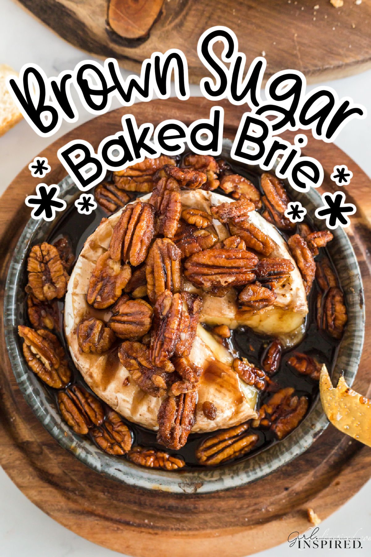 Brown sugar baked brie with pecans with a scoop missing from the wheel.