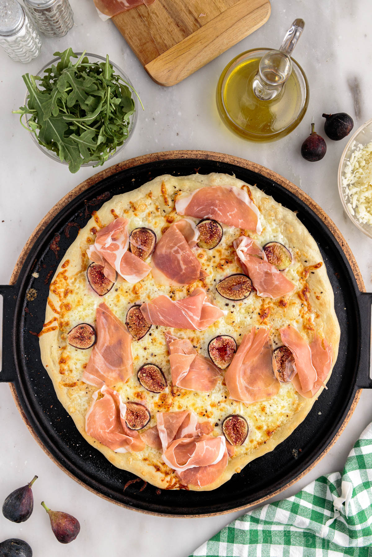 Prosciutto slices mounded on baked fig prosciutto pizza.