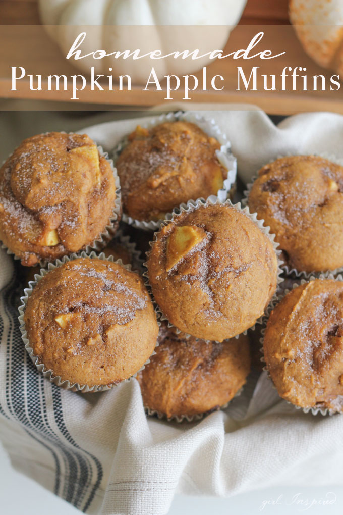 pumpkin apple muffins stacked on a white and blue striped linen, with pumpkins in the background.