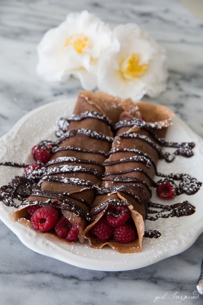 Chocolate Raspberry Crepes - These indulgent crepes are made with a chocolate batter and filled with fresh raspberries and doused with rich, chocolate ganache. YUM!