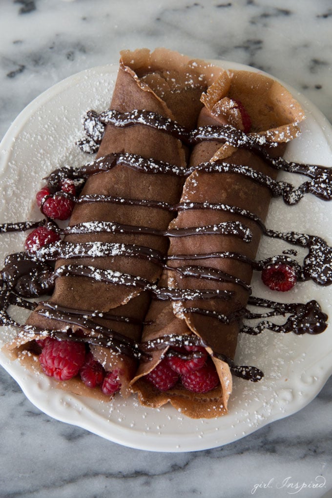 Chocolate Raspberry Crepes - These indulgent crepes are made with a chocolate batter and filled with fresh raspberries and doused with rich, chocolate ganache. YUM!