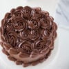 dark chocolate buttercream piped swirls and border on white cake platter