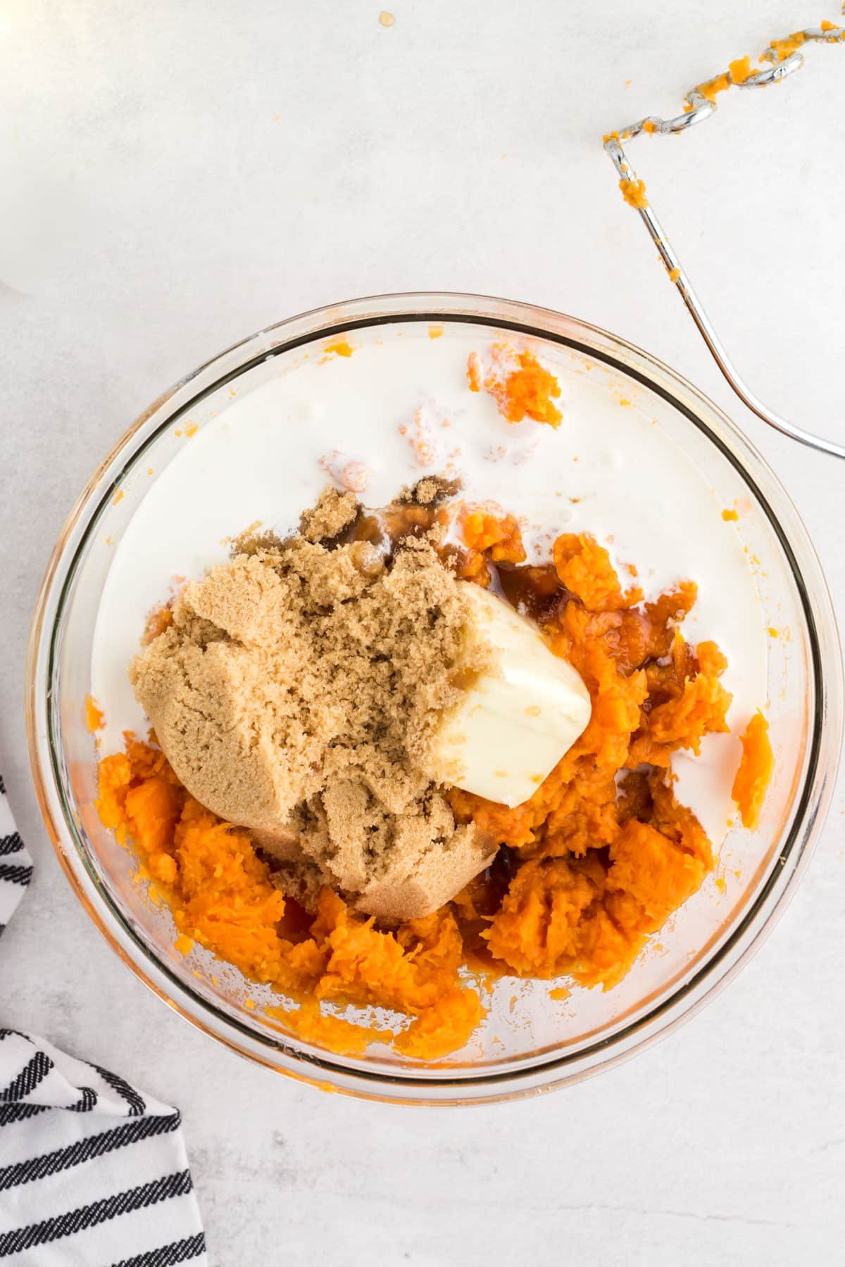 sweet potato flesh, brown sugar, butter, cream, and vanilla in a bowl.