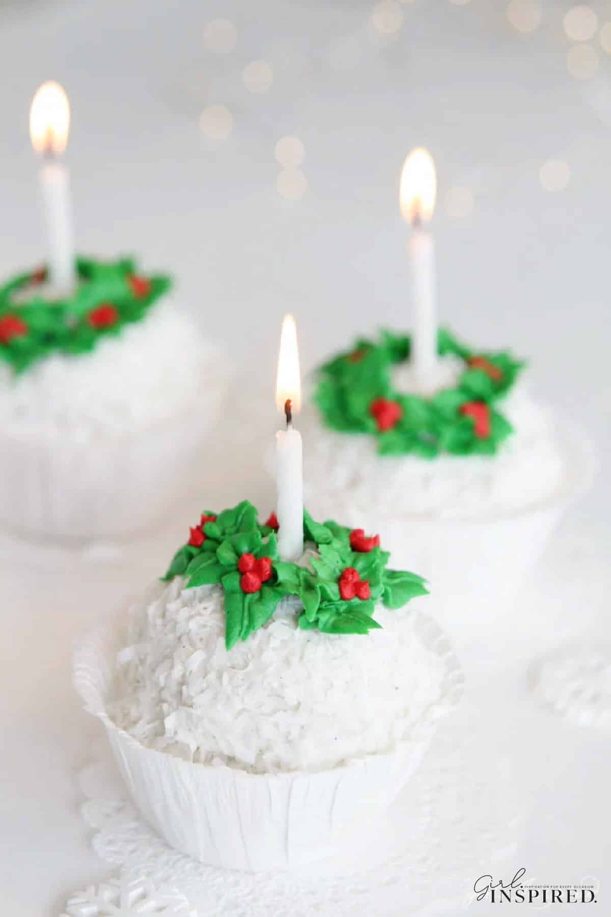 Three cups of snowball ice cream with lit candles.