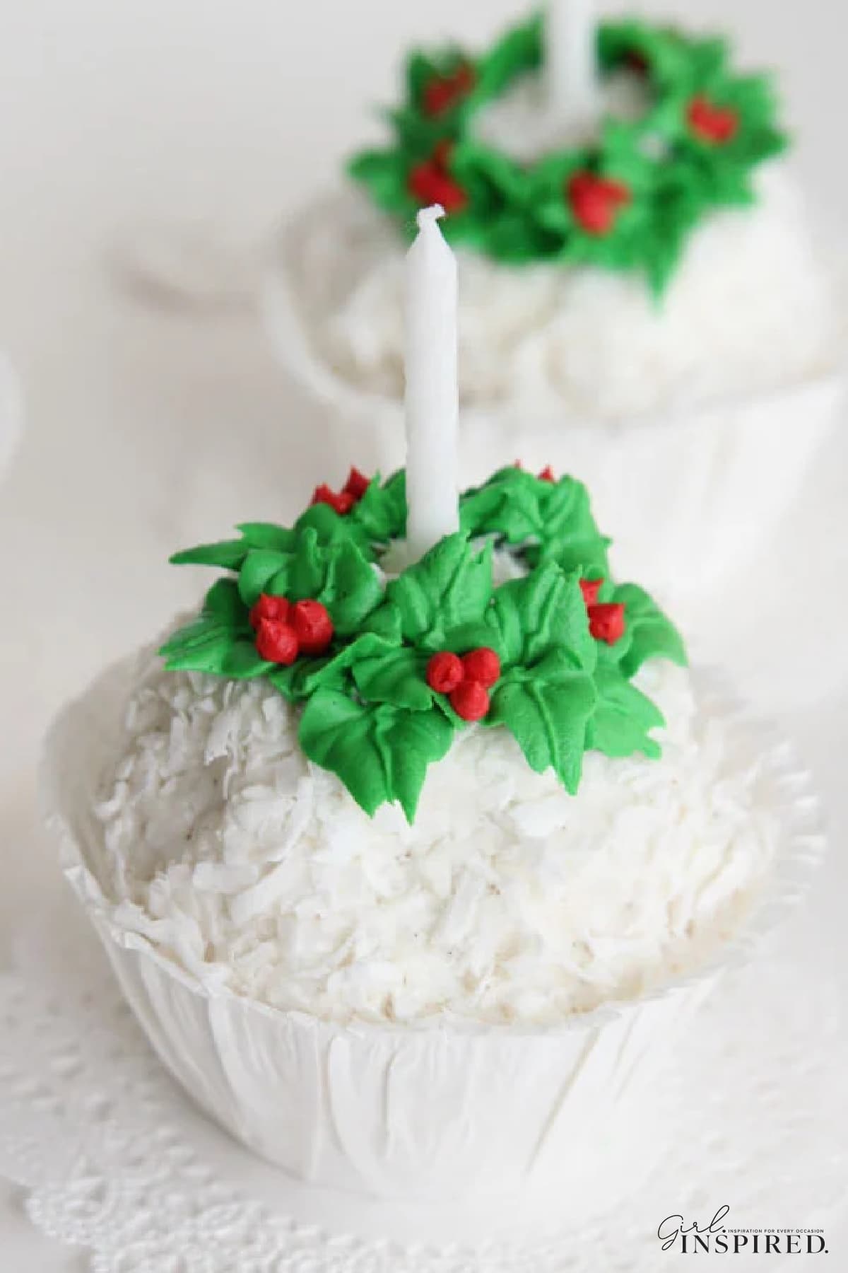 Snowball ice cream with icing wreath around the top and candle in the center, in a paper cup.