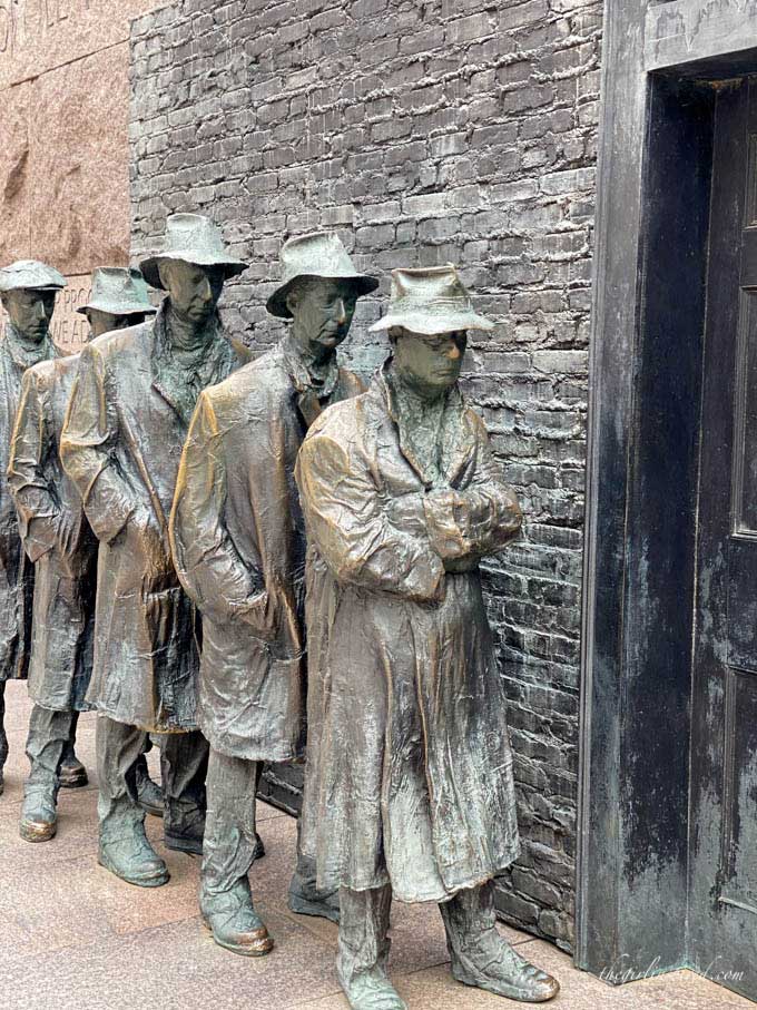 sculptures of men waiting in a bread line with brick background and door