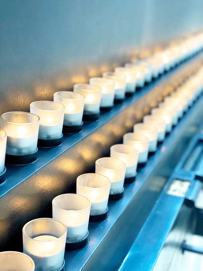 rows of lit tea light candles