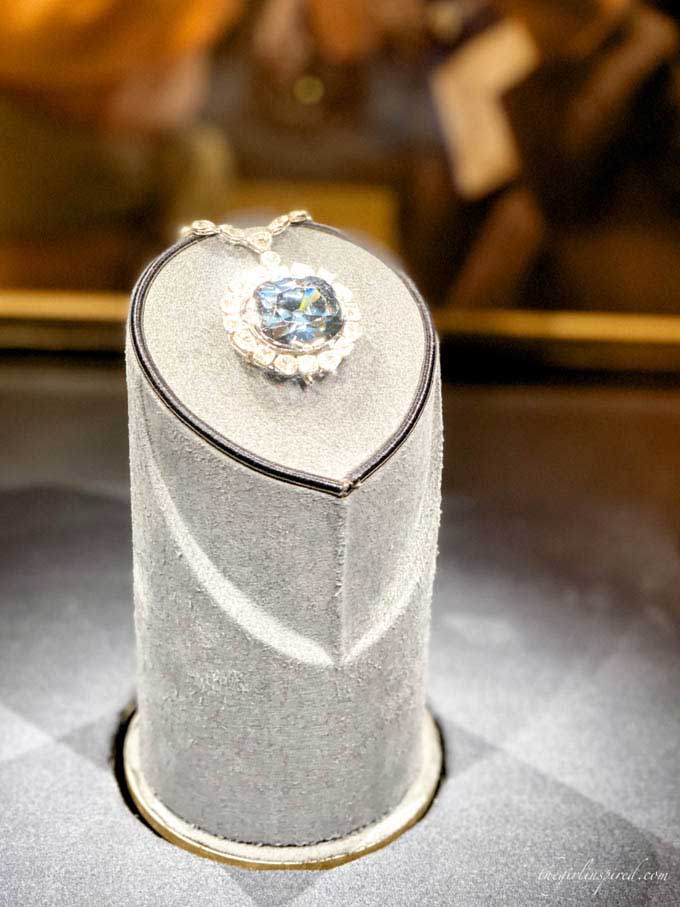 light blue Hope Diamond surrounded by clear diamonds in a museum display case