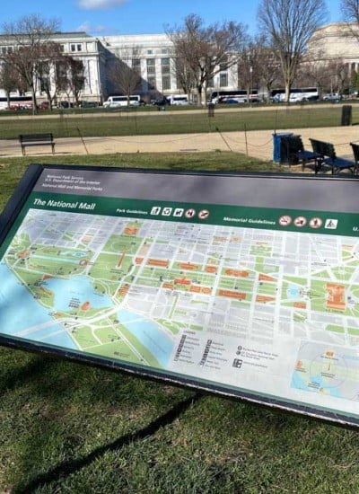 close up of park map with grass and museum buildings in the background