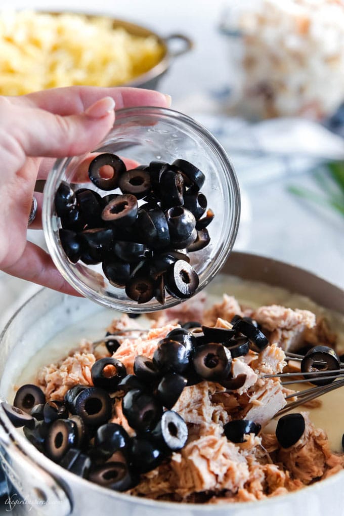 dish of sliced olives poured into saucepan with tuna