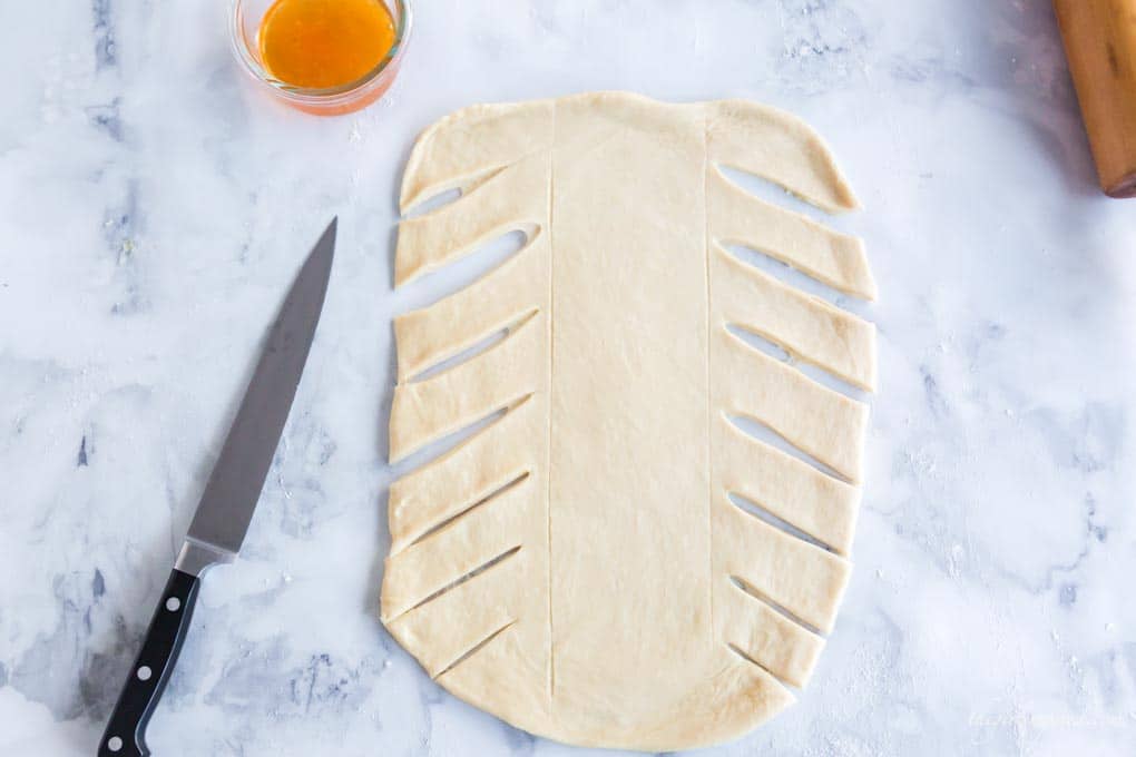 sweet bread dough rolled flat and cut to prepare for braiding