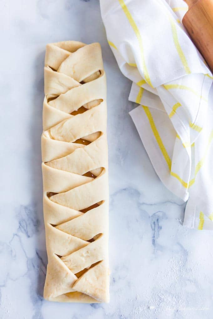 braided dough on marble counter with yellow dish towel