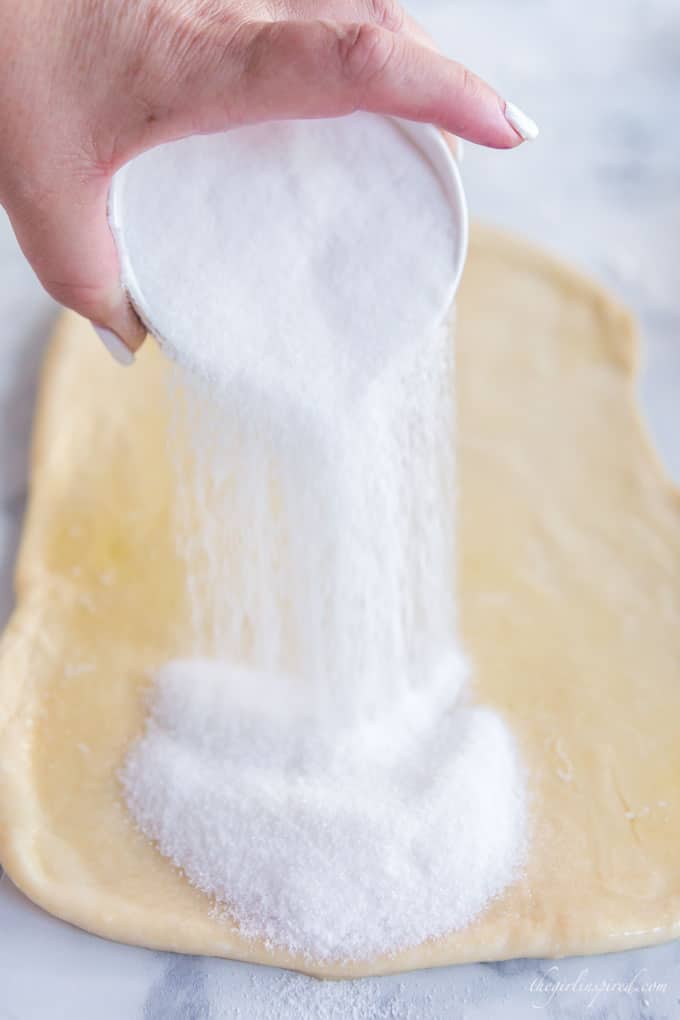 sugar spreading over rolled out sweet dough