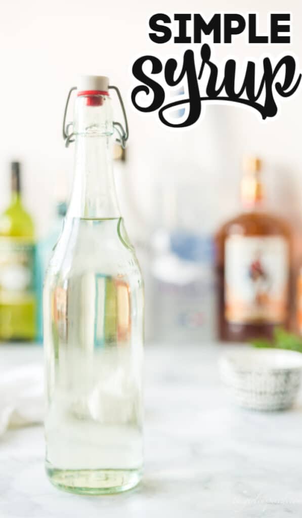 tall glass bottle of simple syrup with other alcohol bottles in the background