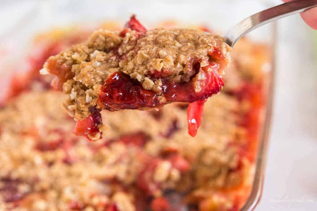 Closeup of spoonful of strawberries and oat crisp topping