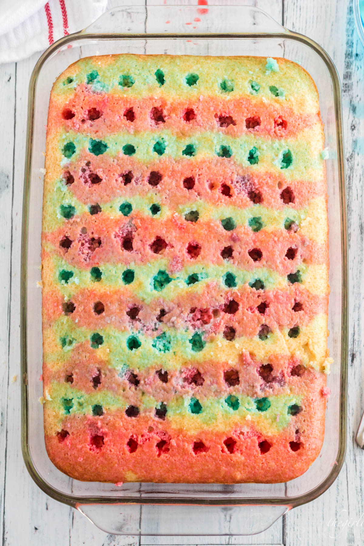 Sheet cake with lines of blue and red jello poured into the holes.