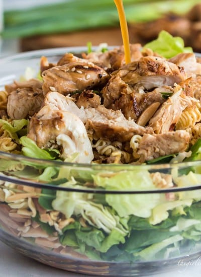 dressing drizzling over the top of grilled chicken-topped chinese chicken salad.