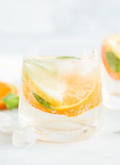 orange, lemon, and basil slices in glasses with ice and club soda