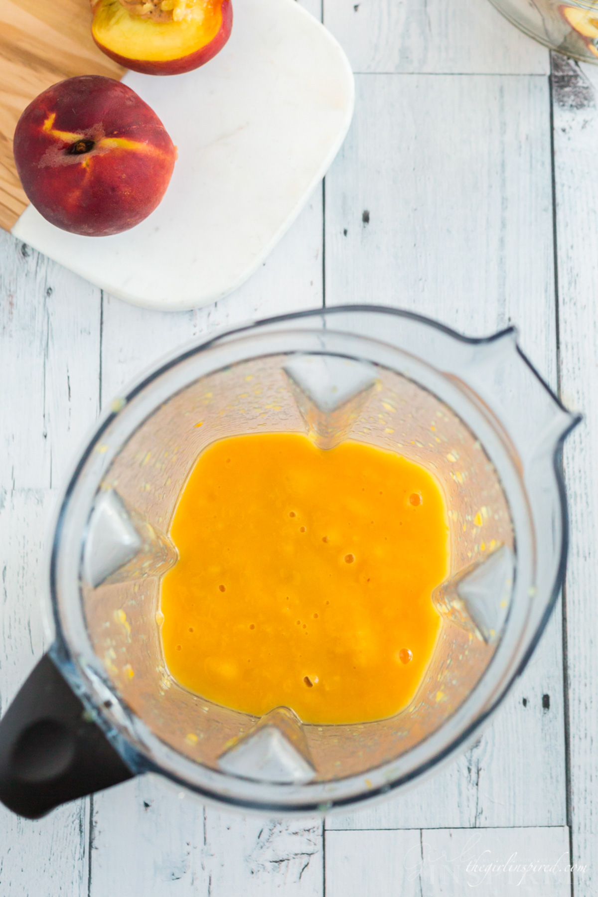 Blended peach and mango puree in the carafe of a blender.