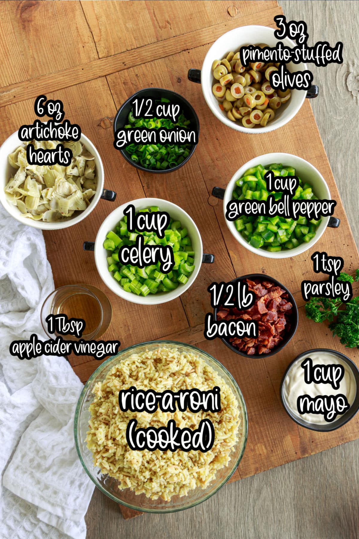 Individual ingredients in bowls and on cutting board for the artichoke rice salad, with text labels.