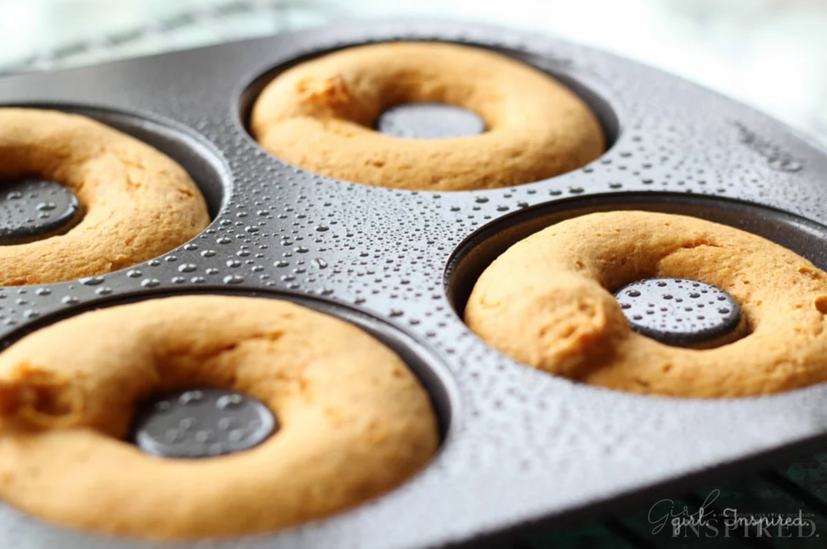 Close up of baked pumpkin donuts in donut pan.