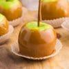 green apples coated in caramel in cupcake wrapper