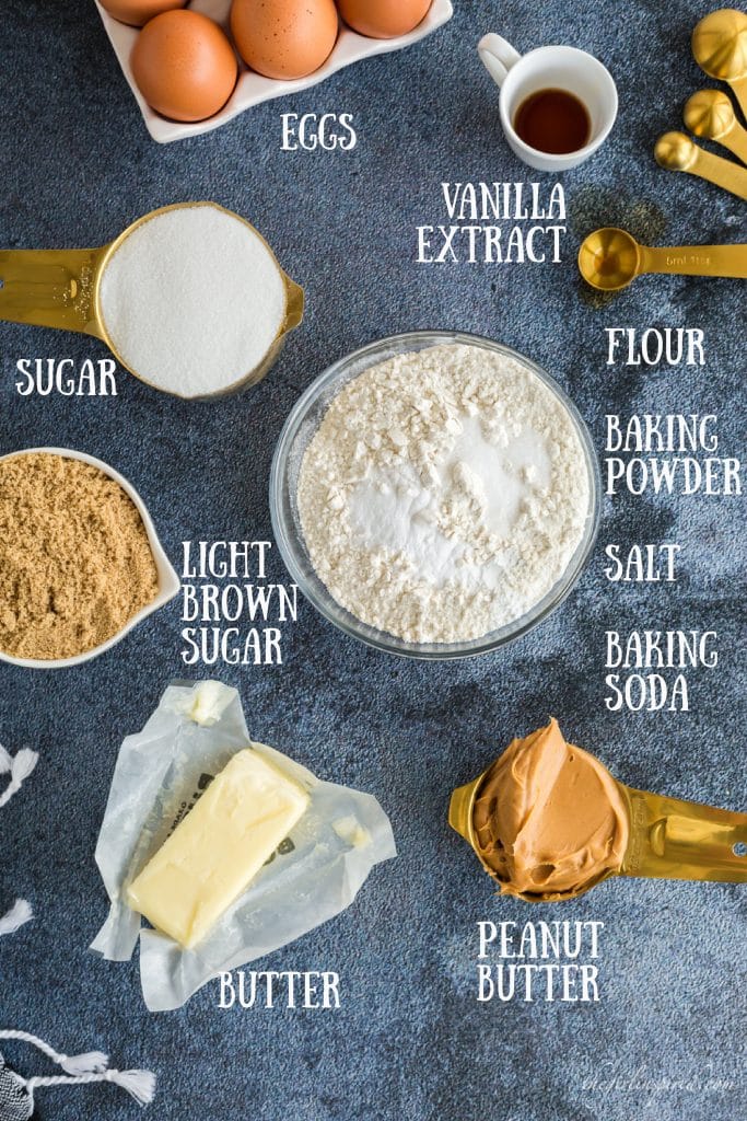ingredients for peanut butter cookie recipe: flour, salt, baking soda, and baking powder in glass bowl, sugar and peanut butter in gold measuring cups, stick of butter in wrapper, brown eggs, vanilla in white cup, and brown sugar in white cup with text overlay
