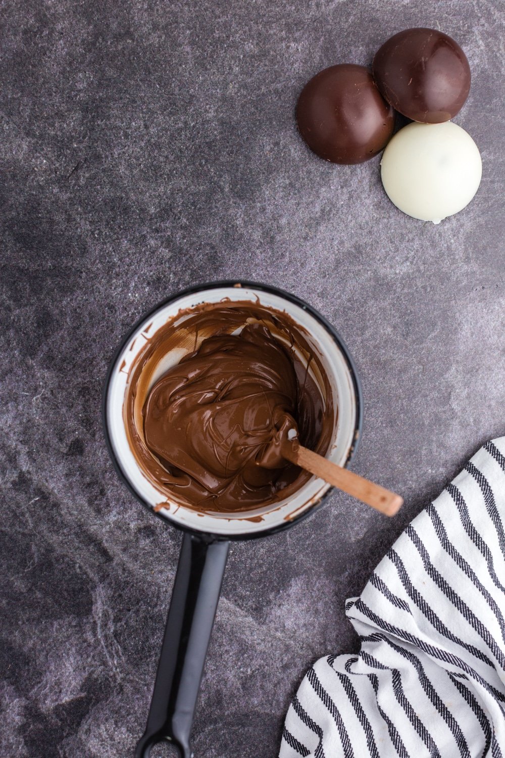 melted chocolate in pan with spatula and tea towel