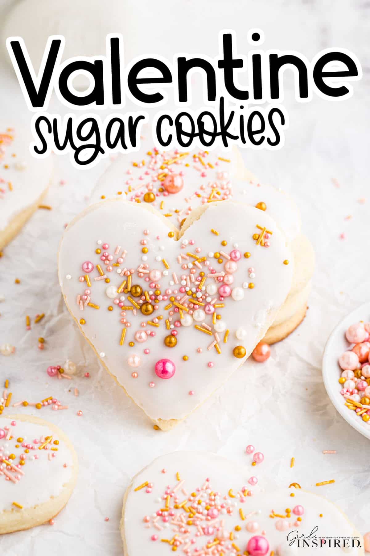 Valentine Sugar Cookies stacked on crumpled parchment paper, decorated with sprinkles, with text title overlay.
