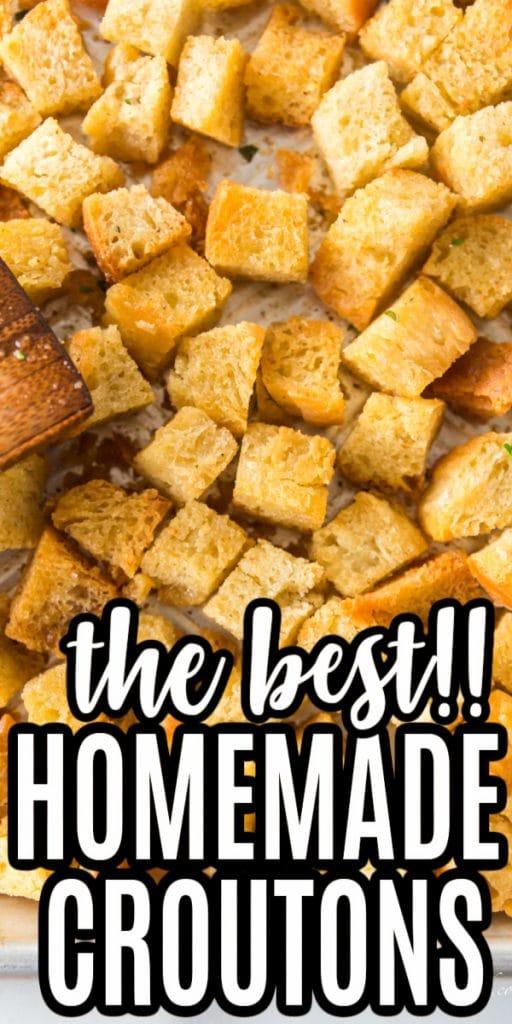 close up of homemade croutons browned and spread out on baking sheet with wooden spatula with text overlay