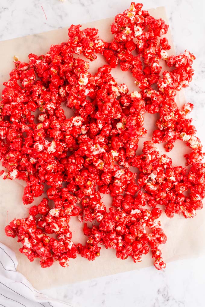red popcorn spread out on parchment paper