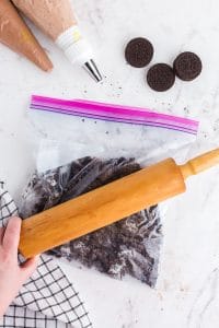 ziploc bag with oreo cookies being crushed with a rolling pin