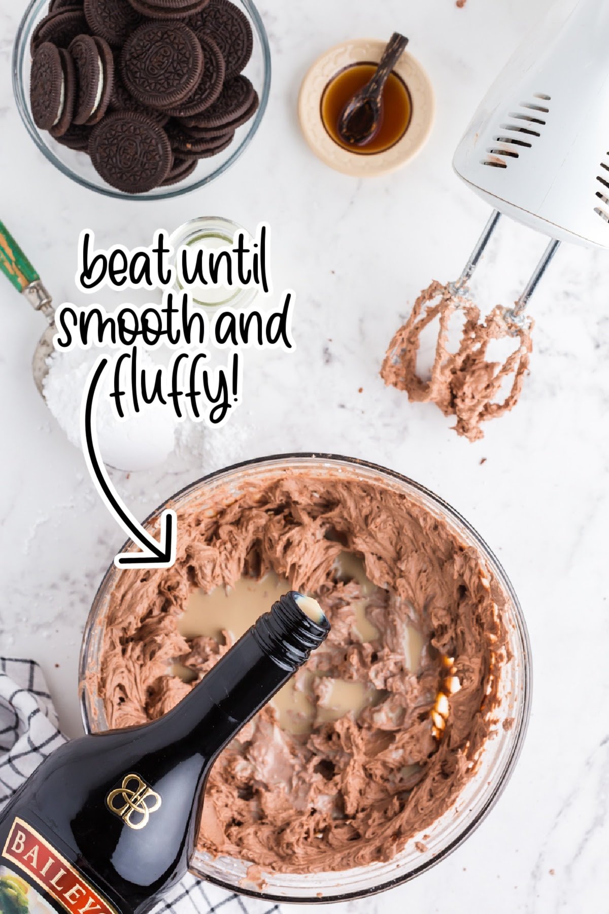 Bailey's being poured into glass mixing bowl with chocolate cheesecake mixture and text "beat until smooth and fluffy."