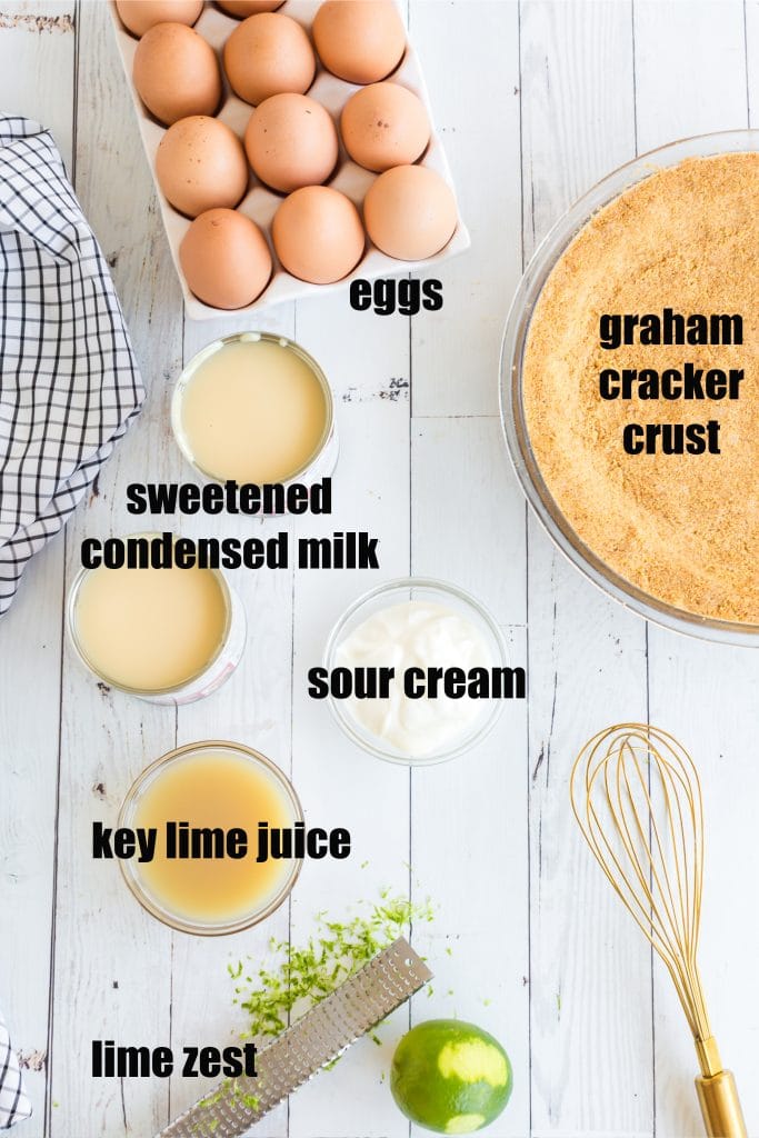 eggs, sweetened condensed milk, lime juice, sour cream, zest, a whisk, and graham cracker crust laid out in individual bowls