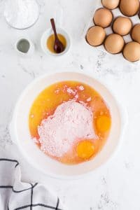 cake mix, eggs, and other ingredients in white mixing bowl