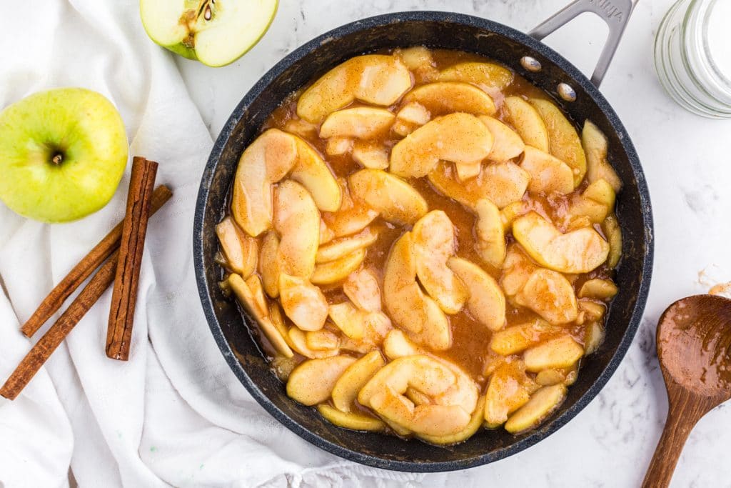 Frying pan with Fried Apples on marble countertop