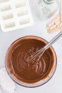 pudding mix whisked together in a glass bowl, popsicle mold, popsicle sticks, empty milk bottle