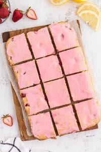 Glazed and cut Strawberry Lemon Blondie on wooden kitchen board on marble countertop
