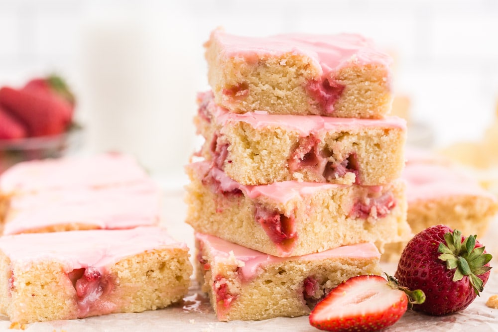 Four pieces of Strawberry Lemon Blondie piled up on top of each other, strawberry in front