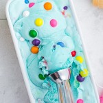 blue bubblegum ice cream with scoop in white loaf pan