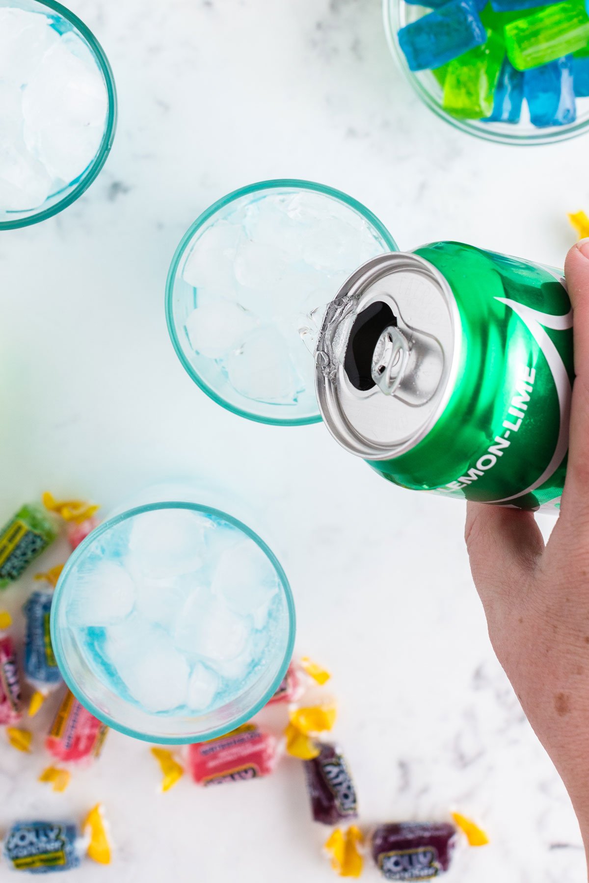 Can of Sprite being poured into cocktail glass to make the Jolly Rancher cocktails.